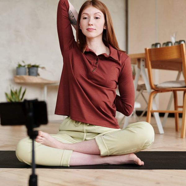 Smiling pregnant woman meditating on a yoga mat.